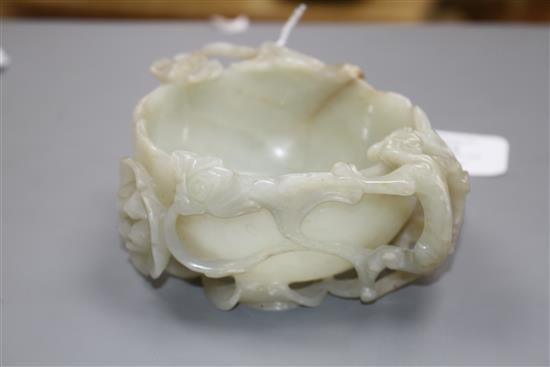 A Chinese pale celadon jade lotus cup, late Ming dynasty, W.13cm, associated wood stand